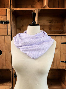 Image of the story excerpt infinity scarf featuring text from Alice's Adventures in Wonderland written by Lewis Carroll. Scarf is white with lilac cursive text. Scarf is shown on a mannequin.