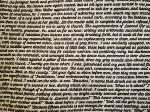 Detail of story excerpt scarf featuring text from Jane Eyre in bold black cursive font on white background.