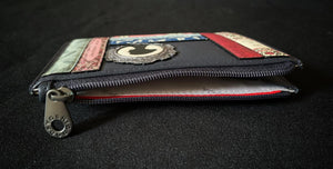  Image shows the blue Yoshi leather zip coin purse qith the zipper open showing the white cotton lining inside printed with repeat Yoshi branding in grey.
