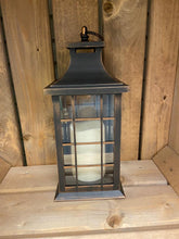 Load image into Gallery viewer, Image showing a bronze coloured Bright Ideas lantern with a square lattice pattern on the windows with a battery operated candle inside and a handle on the top.