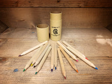 Load image into Gallery viewer, Image shows the Rainbow Word Wand Tube with the lid removed and all 12 coloured pencils laid out in front. Pencil shafts are all natural wood.