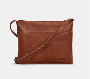 Image shows the back of the brown Yoshi leather cross body bag. Adjustable strap and back slip pocket is seen. Leather is stamped with YOSHI and a genuine leather symbol at the bottom.