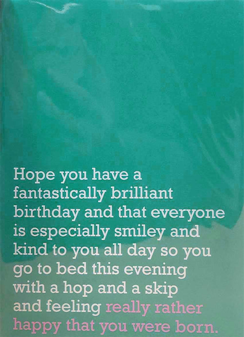 Image of front of greeting card featuring message in white text on teal background saying 'Hope you have a fantastically brilliant birthday and that everyone is especially smiley and kind to you all day so you go to bed this evening with a hop and a skip and feeling really rather happy that you were born'. The 'really rather happy that you were born' is printed in pink.