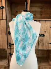Load image into Gallery viewer, Image of the story extract scarf &#39;Extract from a tale on the moors&#39; with a printed pattern of sky blue striped clouds, white clouds and swallows in grey, blue and white on a baby blue background. Scarf displayed tied around a mannequin.