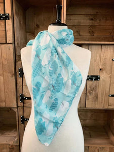 Image of the story extract scarf 'Extract from a tale on the moors' with a printed pattern of sky blue striped clouds, white clouds and swallows in grey, blue and white on a baby blue background. Scarf displayed tied around a mannequin.