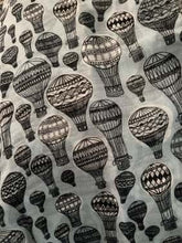 Load image into Gallery viewer, Image of the story extract scarf &#39;Extract from a tale of travel&#39; with a printed pattern of hot air balloons in grey and black. Image shows detail of full print pattern.