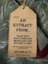 Load image into Gallery viewer, Image of the story extract scarf &#39;Extract from a tale on the rugged plains&#39; with a printed pattern of linear rolling hills in white and dark teal with groups of brown and tan horses galloping amid a linear white dust cloud on a background of olive green. Kraft paper label is shown with description &#39;An extract from tales that spam farmland, heartland and rugged plains&#39;.