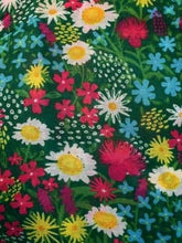 Load image into Gallery viewer, Image of the story extract scarf &#39;Extract from a tale of gardens&#39; with a printed pattern of stylized daisies, forget-me-nots, dandelions and tiny pink flowers on a grass-green background. Image shows detail of full printed pattern.