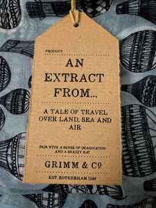 Image of the story extract scarf 'Extract from a tale of travel' with a printed pattern of hot air balloons in grey and black. Kraft paper label shown with description saying 'an extract from a tale of travel over land, sea and air'..