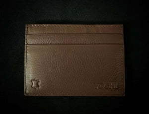 Image of the back of the brown leather travel-themed card holder. Design is plain brown leather on the back but features two slip pockets for extra card storage and embossed Yoshi branding in the corner.