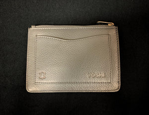 Image shows the back of the Yoshi leather Coin Keeper purse. Purse is dark grey with a back slip pocket and zip across the top. 
