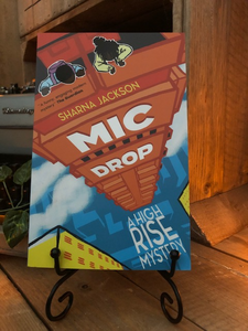 Image shows the front cover of the paperback book Mic Drop written by Sharna Jackson and part of the High Rise Mystery series.