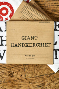 Image shows the kraft paper label of the Giant Handkerchief, otherwise known as a cotton tea towel.