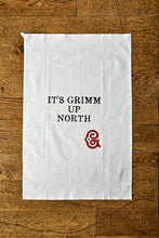 Load image into Gallery viewer, Image shows the Giant Handkerchief unfolded to display slogan printed in black on white cotton tea towel. Slogan reads &#39;IT&#39;S GRIMM UP NORTH&#39; with the Grimm &amp; Co red &#39;G&#39; monogram underneath.