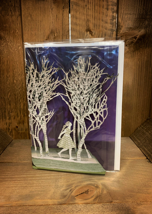 Image showing an A5 greetings card with a design showing a laser cut out card with a purple background (inside the card). The card has laser cut trees coming up from the pages of an open book and Snow White wandering through the trees with a rabbit following behind her. 