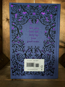 Image of the back cover of the Puffin clothbound classic Black Beauty with a purple background and a print of black rose thorns with purple foiled roses and buds in a mirrored pattern. In the centre is a purple foil print of a quote from the story - 'Do your best and keep up your good name.'