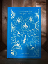 Load image into Gallery viewer, Image of the clothbound classic book Around the World in 80 Days with a kingfisher blue background. The front cover features a cream print design with images of vintage travel stickers from the various locations that Phileas Fogg travels to in the book.