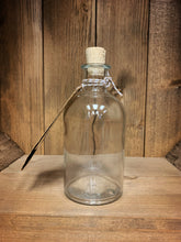 Load image into Gallery viewer, Image shows a side view of the Airs and Graces bottle. It is an empty, corked glass bottle, with a kraft label tied around the neck.