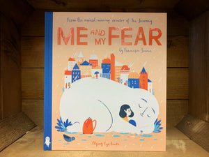 Image shows the front cover of the hardback book Me and My Fear with a beige background, orange and blue text and a bright illustration of a girl surrounded by her fear depicted as a large round white character laid in front of a city.