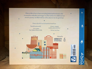 Image shows the back cover of The Journey with a beige background and blue text. Illustration at the bottom shows a large pile of suitcases and bags with a cat curled up asleep on top.