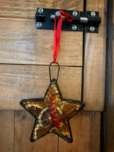 Load image into Gallery viewer, Image of the Scent of the Season Tree Decoration shaped as a star. Decoration is a black wire shaped hanging box with hanging loop and ribbon. Box is filled with pot pourri including dried orange and green orange slices, a dried red chilli and cinnamon stick. Image shows the decoration hanging using the red ribbon.
