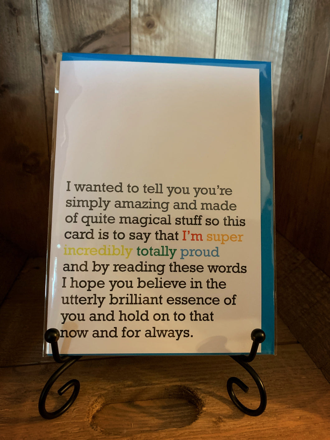 Image of greetings card Incredibly Totally Proud with a white background and dark grey text saying 'I wanted to tell you you're simply amazing and made of quite magical stuff so this card if to say that I'm super incredibly totally proud and by reading these words I hope you believe in the utterly brilliant essence of you and hold on to that now and for always.' The words I'm super incredibly totally proud are coloured red, orange, yellow, green and blue,