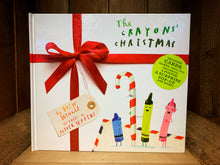 Load image into Gallery viewer, Image showing the front cover of The Crayons&#39; Christmas with illustrations of Green, Blue and Pink crayons with an elderly candy cane. A sticker says &#39;Includes cards, games, press-out ornaments, a poster, a surprise pop-up and more!&#39;