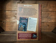 Load image into Gallery viewer, Image of the Jigsaw Library The Hound of the Baskervilles showing the back cover of the book-shaped box and the double-sided puzzle design with the image and an excerpt from the story.