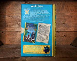 Image of the Jigsaw Library Treasure Island showing the back cover of the book-shaped box and the double-sided puzzle design with the image and an excerpt from the story.