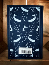 Load image into Gallery viewer, Image of the back cover of the Penguin clothbound classic Moby Dick featuring a navy blue background and a repeat pattern of pale grey whales whale tails with harpoons interspersed among them.