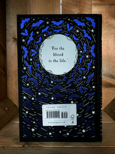 Image of the back cover of the Puffin clothbound classic of Dracula. The cover features a black background with the silhouette of a white full moon surrounded by purple foil bats and white stars. Inside the moon is the quote 'For the blood is the life.'