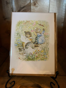 Image of greetings card Beatrix Potter Kittens showing a full-colour image of Tom Kitten and his sisters playing in a garden on a white background