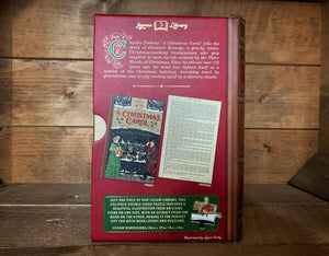 Image of the Jigsaw Library A Christmas Carol showing the back cover of the book-shaped box and the double-sided puzzle design with the image and an excerpt from the story.