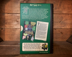 Image of the Jigsaw Library The Great Gatsby showing the back cover of the book-shaped box and the double-sided puzzle design with the image and an excerpt from the story.