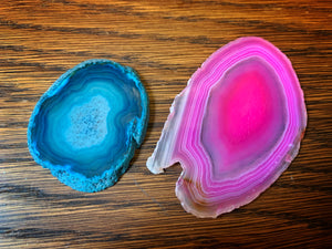 Image of two Crystallized Fairy Wings, one pink and one turquoise with rings of colour in a rounded shape. These glass-like gems are made from agate slices.
