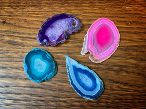 Image of four different coloured Crystallized Fairy Wings in pink, purple, blue and turquoise. all gems are made from slices of agate with patterned rings of colour in slightly different shapes.