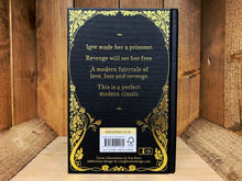 Load image into Gallery viewer, Image shows the back cover of the book A Pocketful of Crows. The blurb is embossed in gold, same as the front, surrounded by a continuation of the leaf patterns from the front.