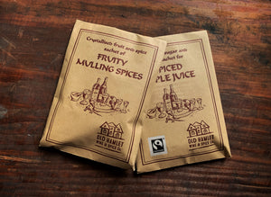 Image shows a top-down view of two kraft paper pouches, one of Fruity Mulling Spices, and one of Spiced Apple Juice spices. 