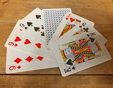 Load image into Gallery viewer, Image shows a fanned-out flat lay of a selection of cards from within the pack. They are standard playing cards, with a patterned back.