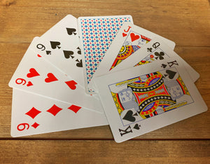 Image shows a fanned-out flat lay of a selection of cards from within the pack. They are standard playing cards, with a patterned back.