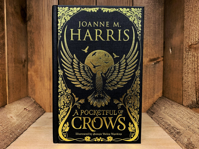 Image shows the front cover of the book A Pocketful of Crows. The book is bound in black coloured cloth, with the title, and flowing patterns and the illustration of a crow embossed in gold.