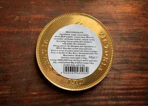 Image shows the back of a Dragon's Hoard chocolate coin, including a label with the ingredients and nutritional information. 