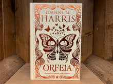 Load image into Gallery viewer, Image shows the front cover of the book Orfeia. The book is bound in cream coloured cloth, with the title, and flowing patterns and butterfly  illustrations embossed in bronze.
