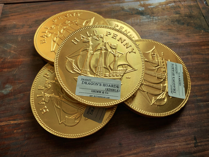 Image shows a pile of five Dragon's Hoard chocolate coins - giant chocolate coins with a gold 'half-penny' embossed foil covering.