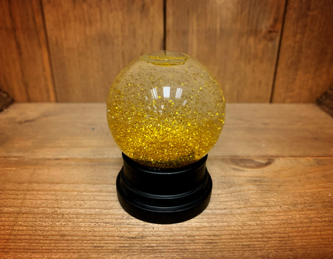 Image of the gold glitter globe after being shaken.