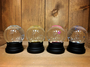 Image of four glitter globes after the glitter has settled. 