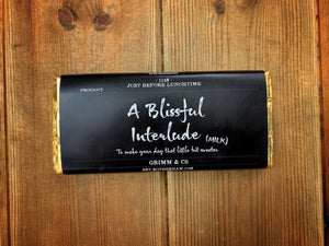 Image shows the Milk Chocolate A Blissful Interlude bar with black label, white text and gold foil.