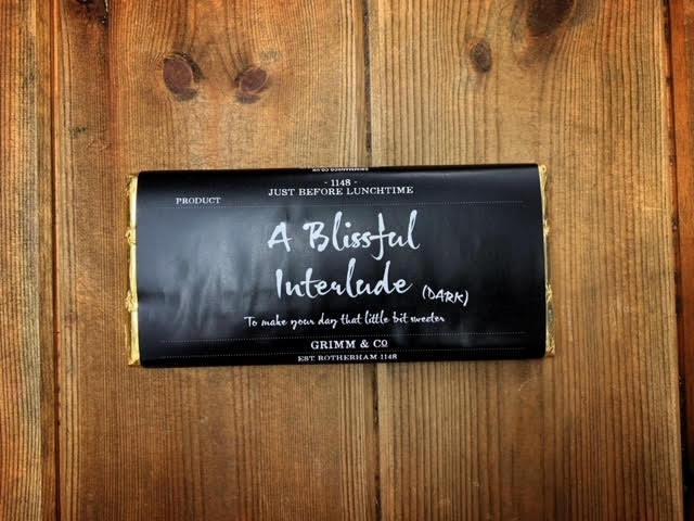 Image shows the Dark Chocolate A Blissful Interlude bar with black label, white text and gold foil.